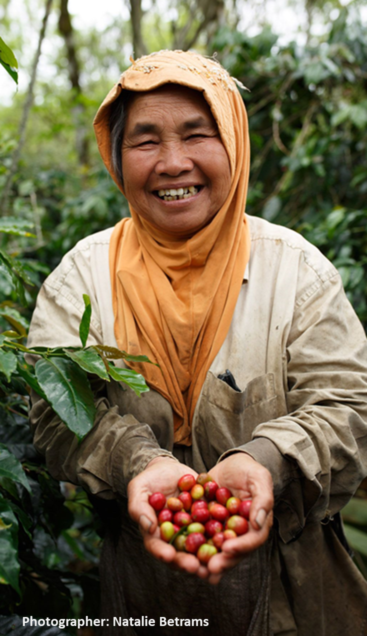 smiling woman holding coffee beans